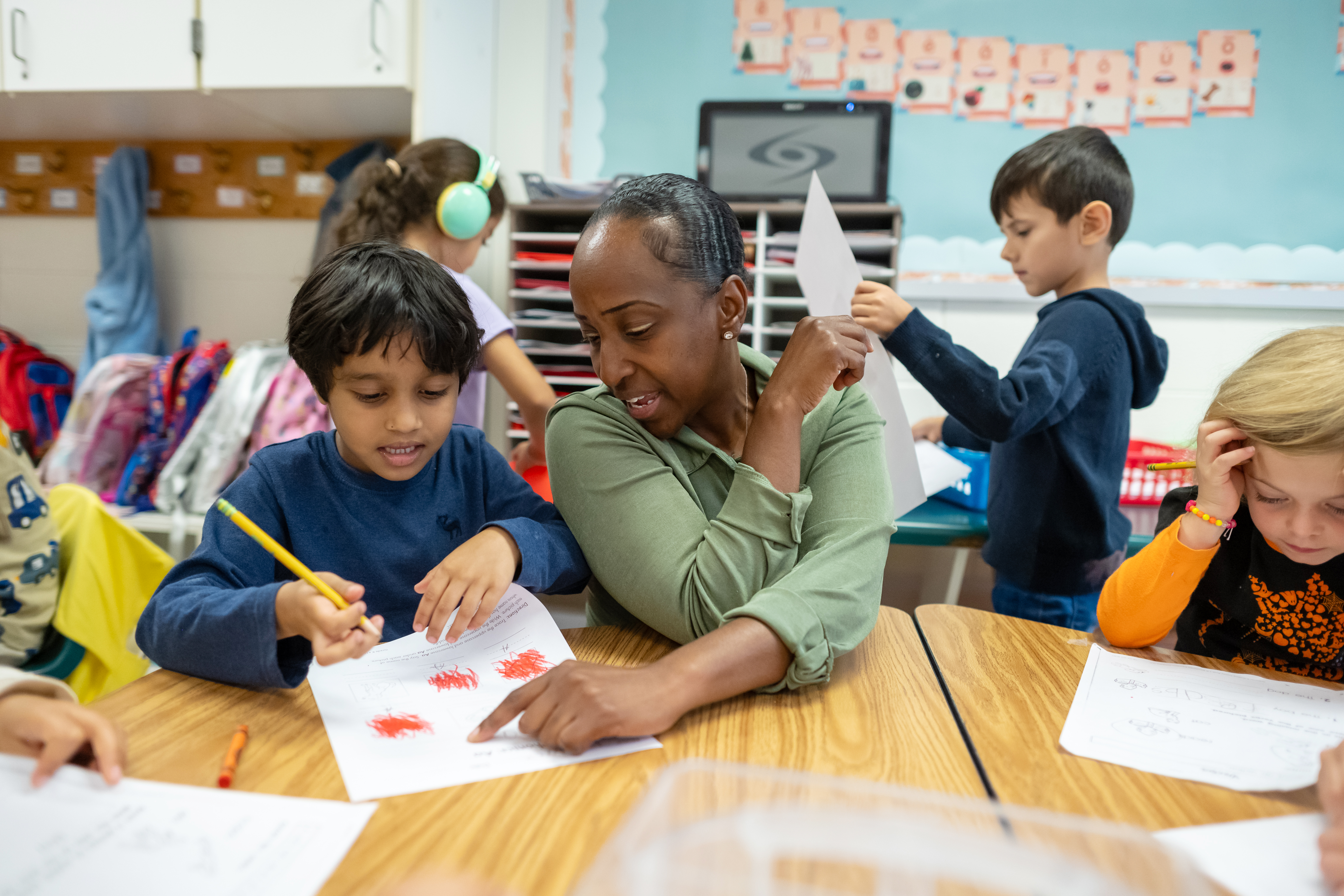 student pointing at student's paper