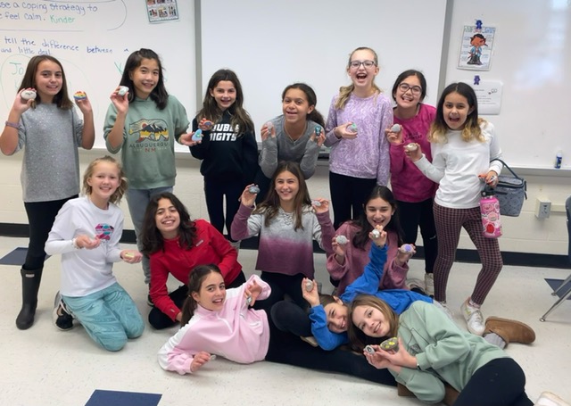 kindness club members pose with painted rocks